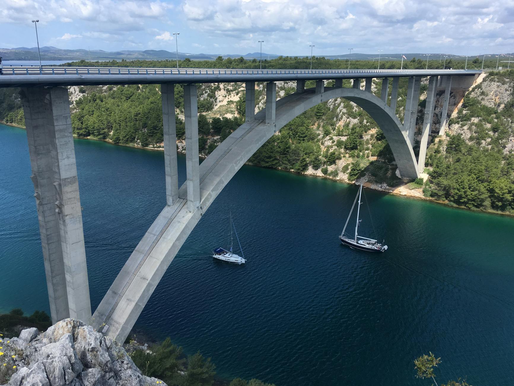 Most łukowy nad szmaragdową rzeką w górzystym krajobrazie Chorwacji