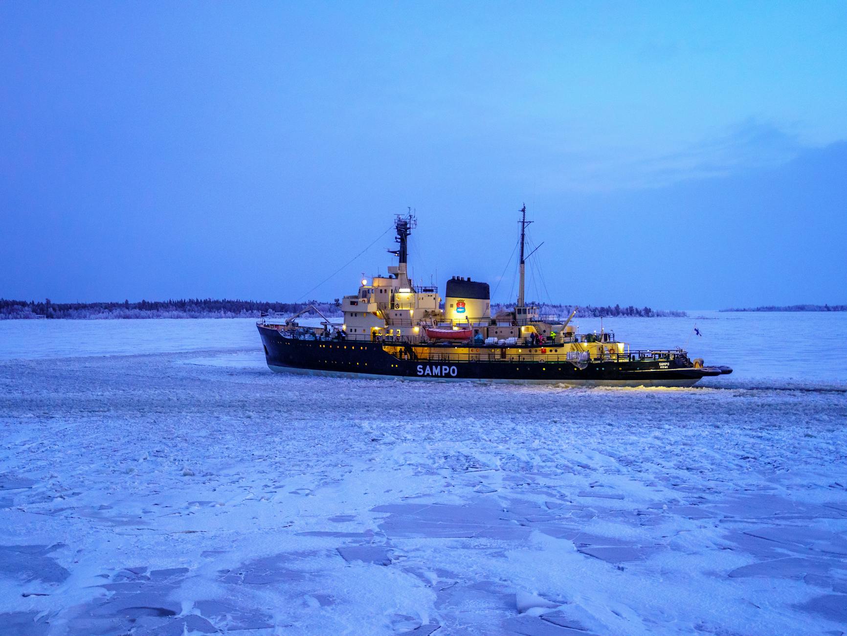 Lodołamacz Sampo płynie o zachodzie słońca po skutej lodem wodzie w Kemi