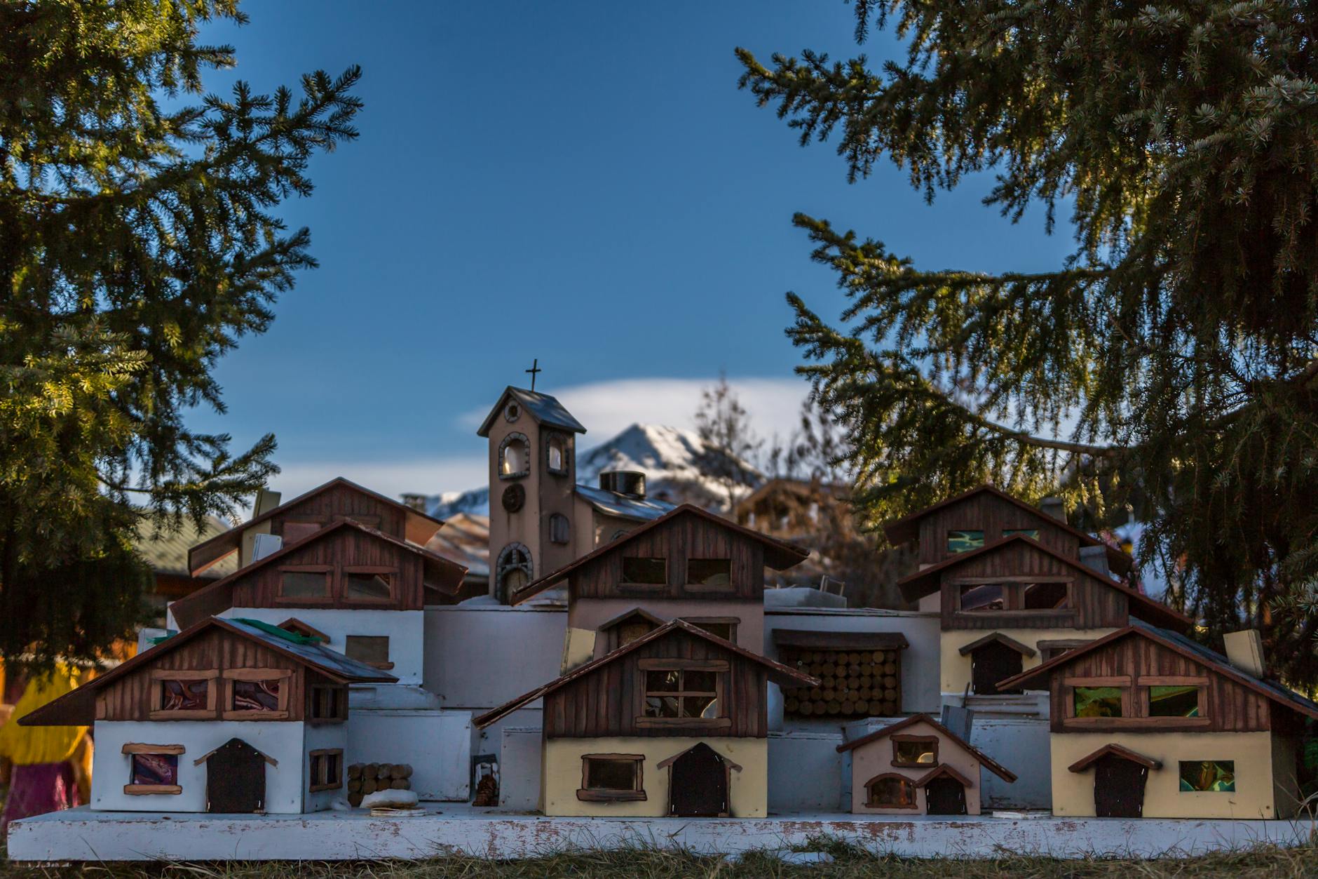 Miniaturowa górska wioska z drewnianym kościołem wśród świerków