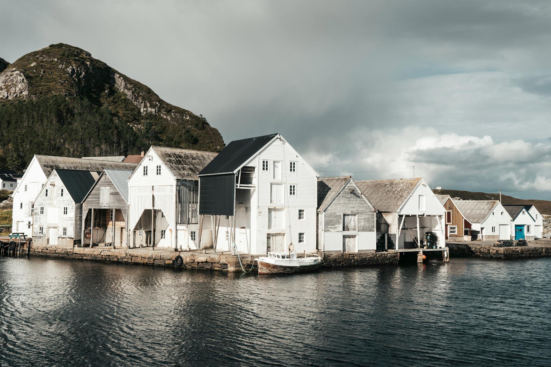 Skandynawska nadmorska wioska rybacka z drewnianymi domami i górami