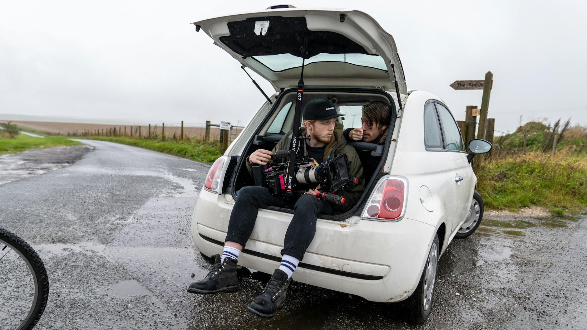 Ekipa filmowa z kamerą w bagażniku samochodu na mokrej brytyjskiej drodze