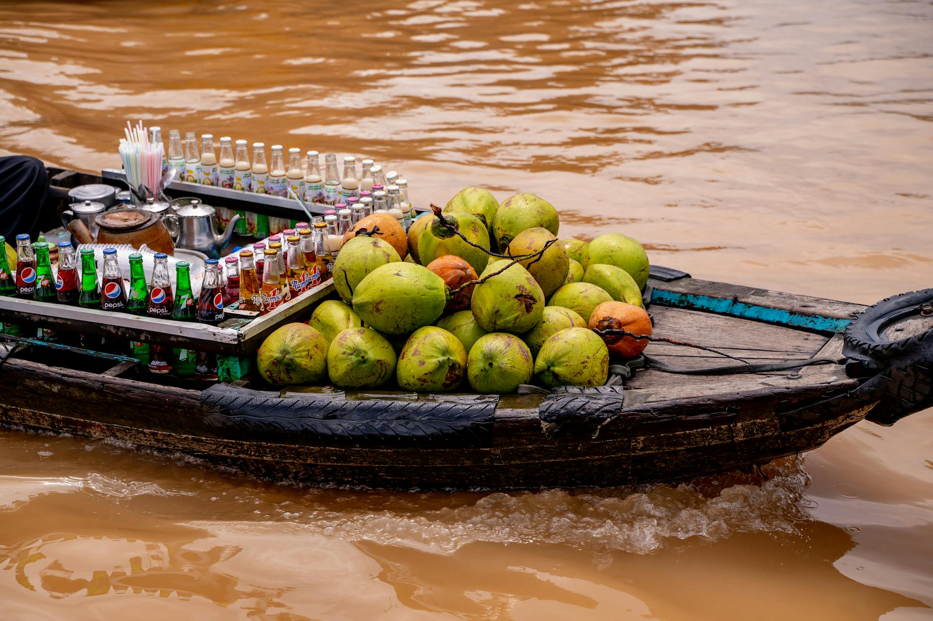 Łódź z kokosami i napojami na pływającym targu w Cần Thơ w Delcie Mekongu
