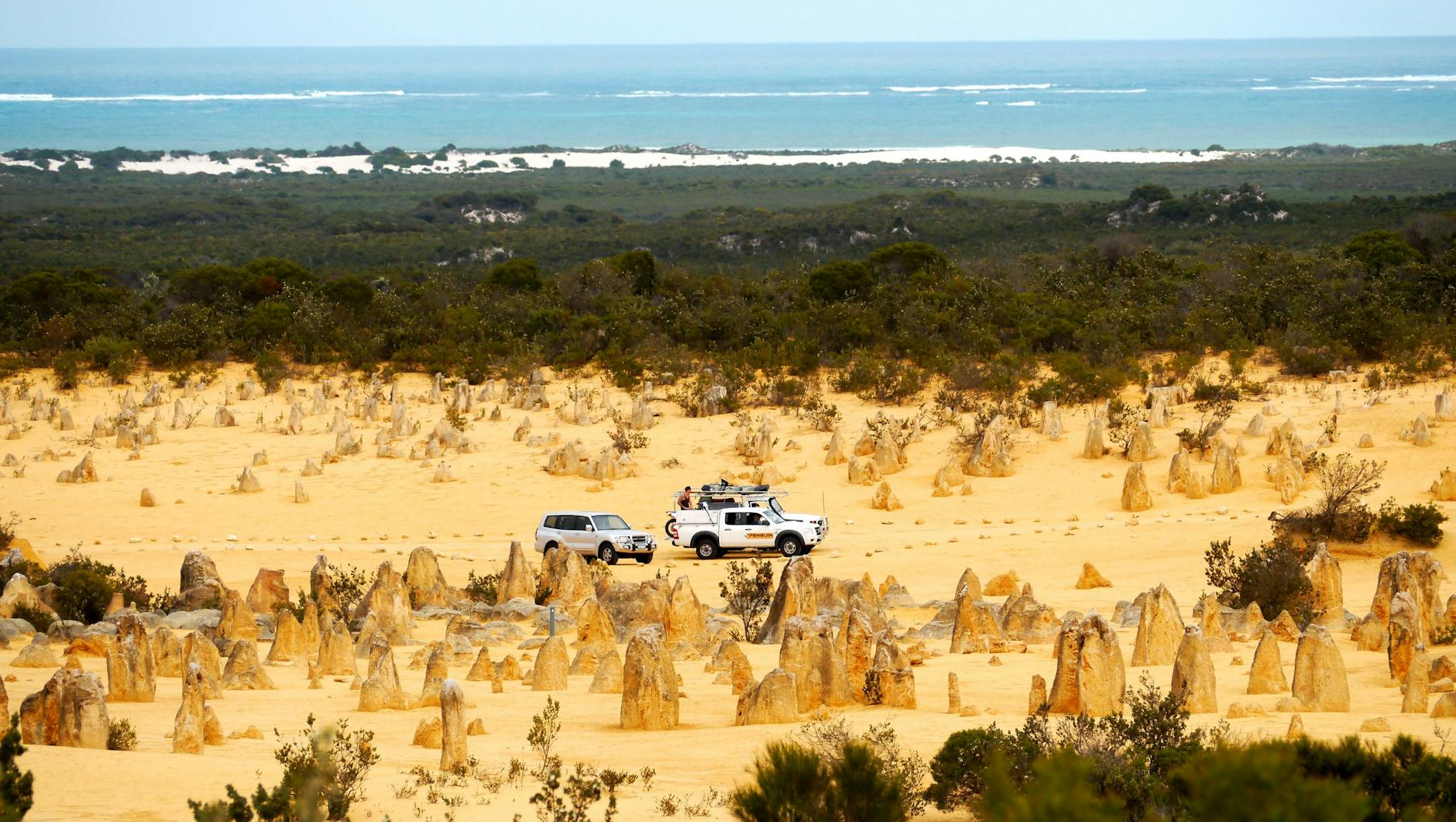 Samochody na pustyni Pinnacles z widokiem na ocean w Australii