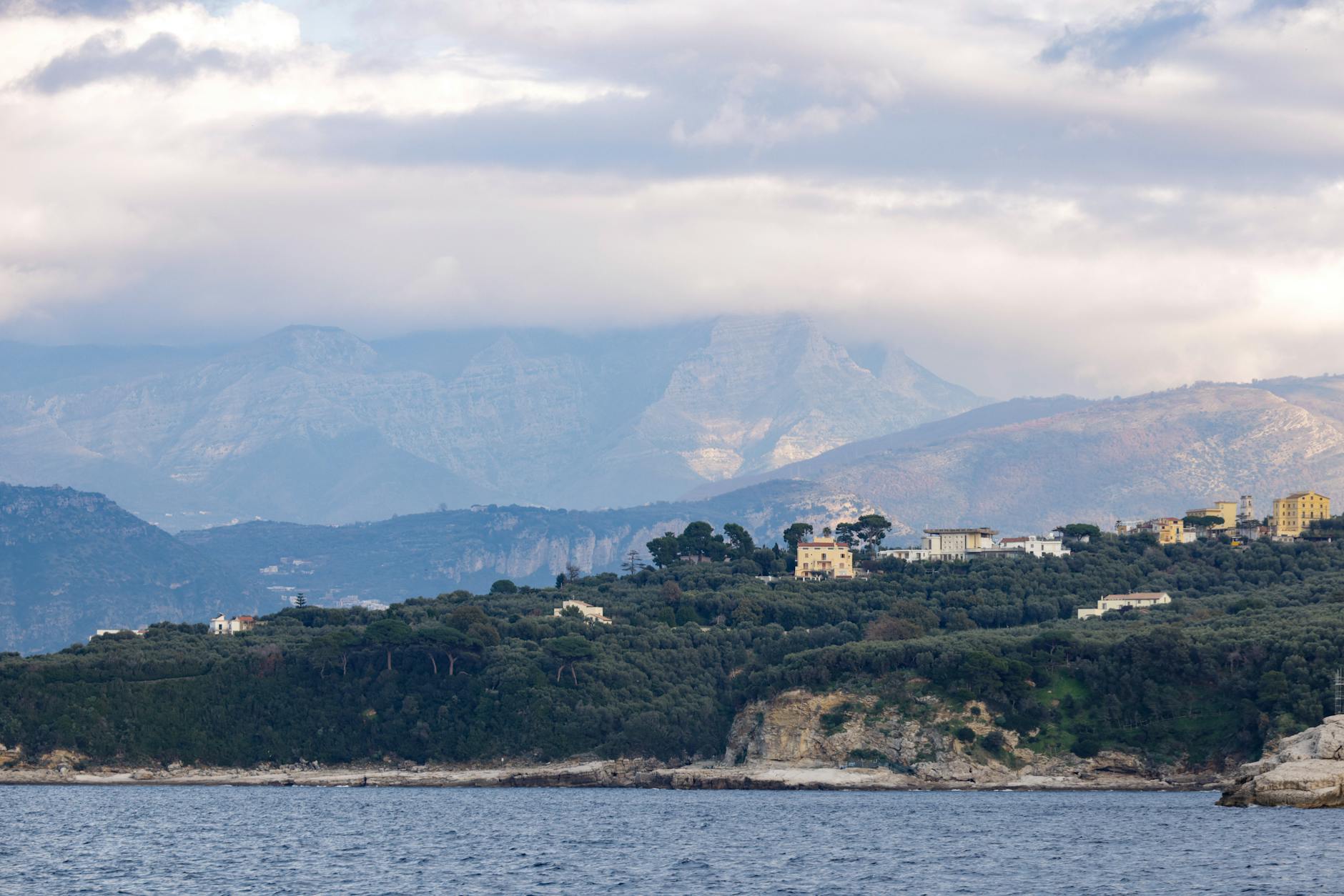 Zielone wybrzeże nad Morzem Śródziemnym z górami w pochmurny dzień