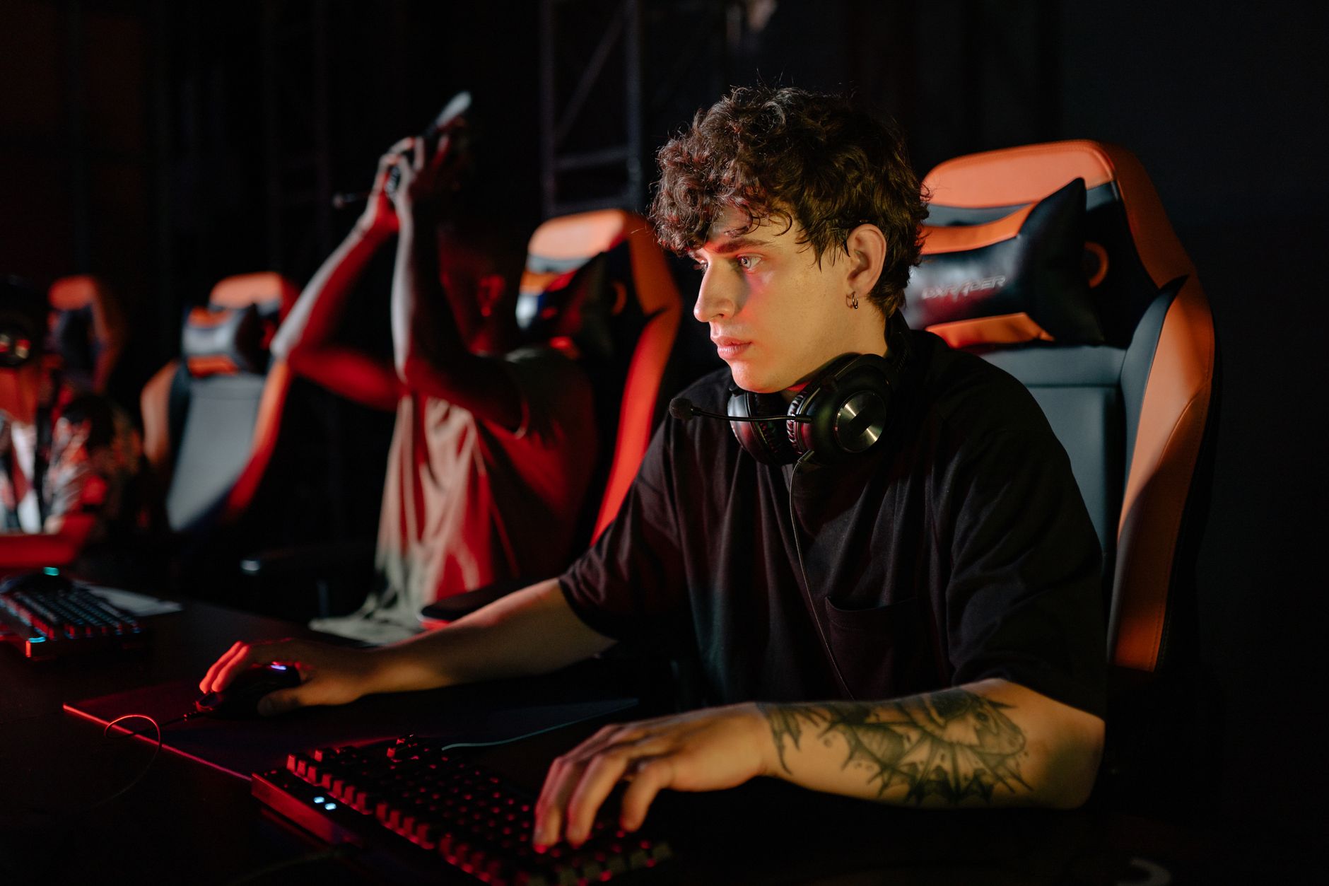 Zawodowi gracze e-sportowi skupieni przy komputerach na turnieju