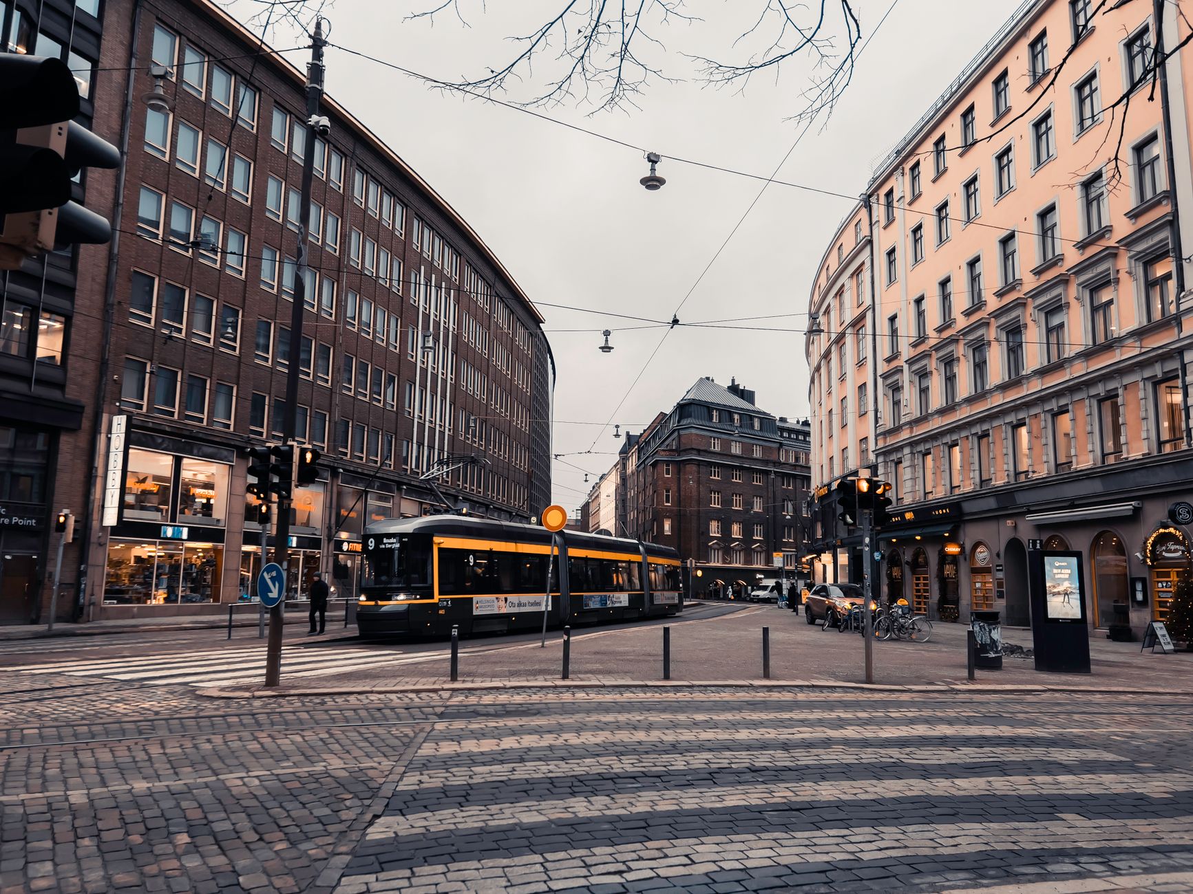 Wieczorna ulica z tramwajem i miejską zabudową w Helsinkach